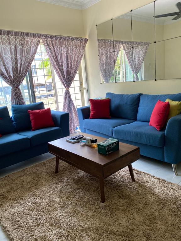a living room with blue couches and a coffee table at Seri Kasturi Apartment in Puchong