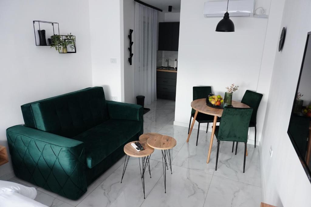 - un salon avec un canapé vert et une table dans l'établissement "Handmade" Apartment, à Niš