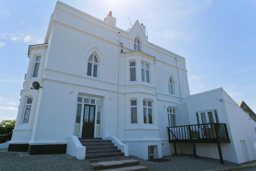 a white building with stairs in front of it at Eryl Mor in Menai Bridge