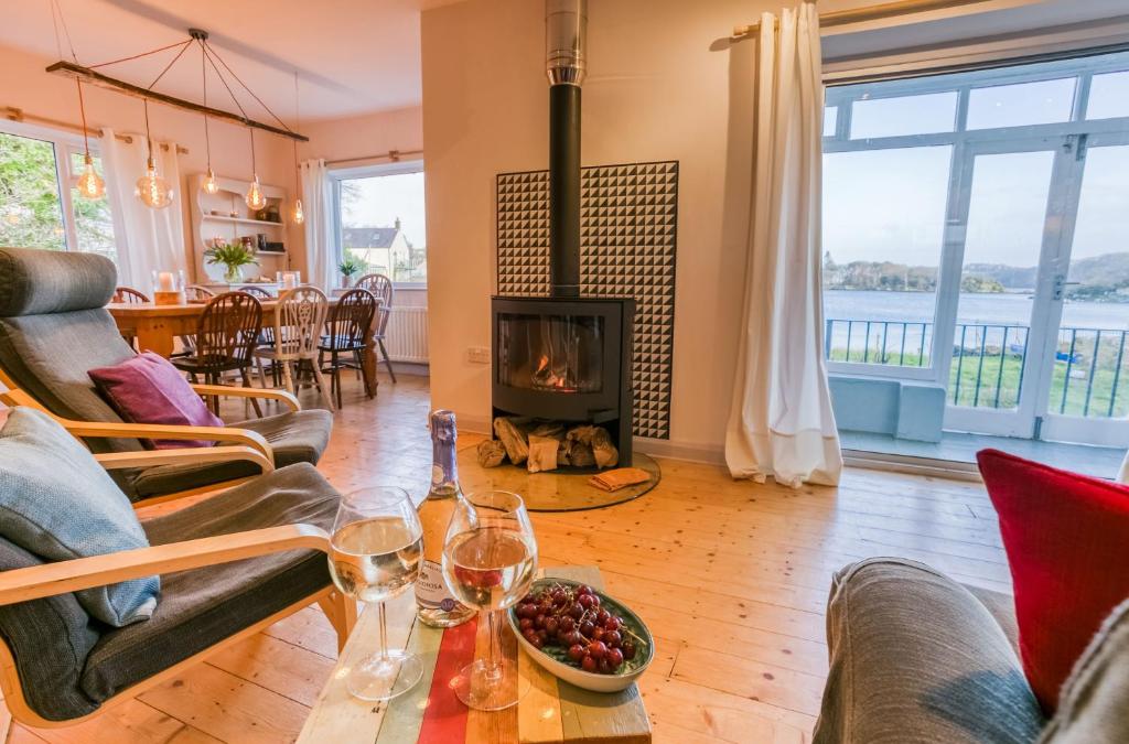 sala de estar con chimenea y mesa con copas de vino en Eigionfa, en Menai Bridge