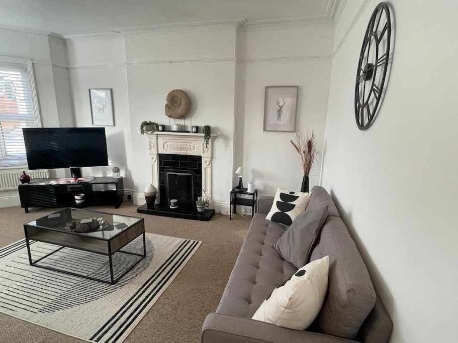 a living room with a couch and a fireplace at 3 bed flat+parking- by beaches in Parkstone