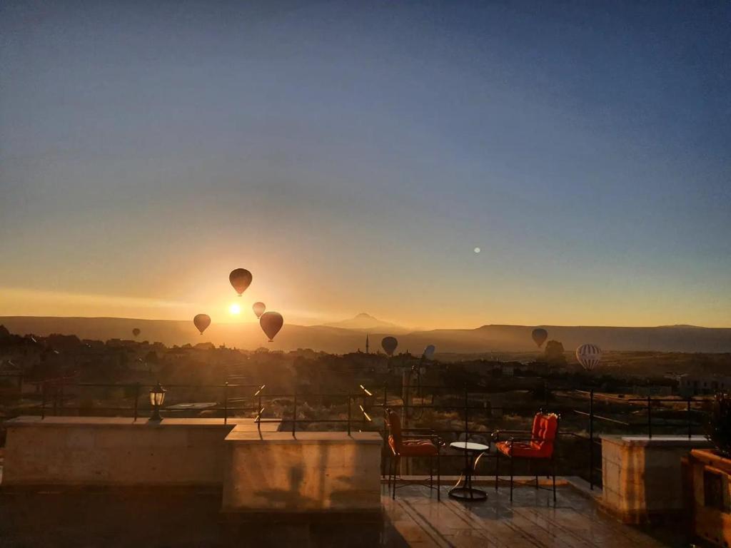 a sunset with hot air balloons in the sky at Cordial Cappadocia Hotel in Ortahisar