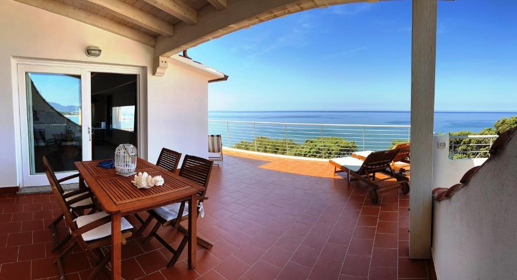 um pátio com uma mesa e cadeiras numa varanda em TITINO stupendo appartamento in villa fronte Mare - Golfo dell'Asinara - Internet Free em Codaruina