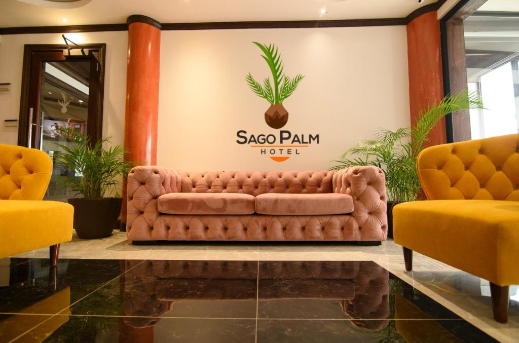 un divano marrone in una hall con due sedie gialle di Sago Palm Hotel a Ocho Rios