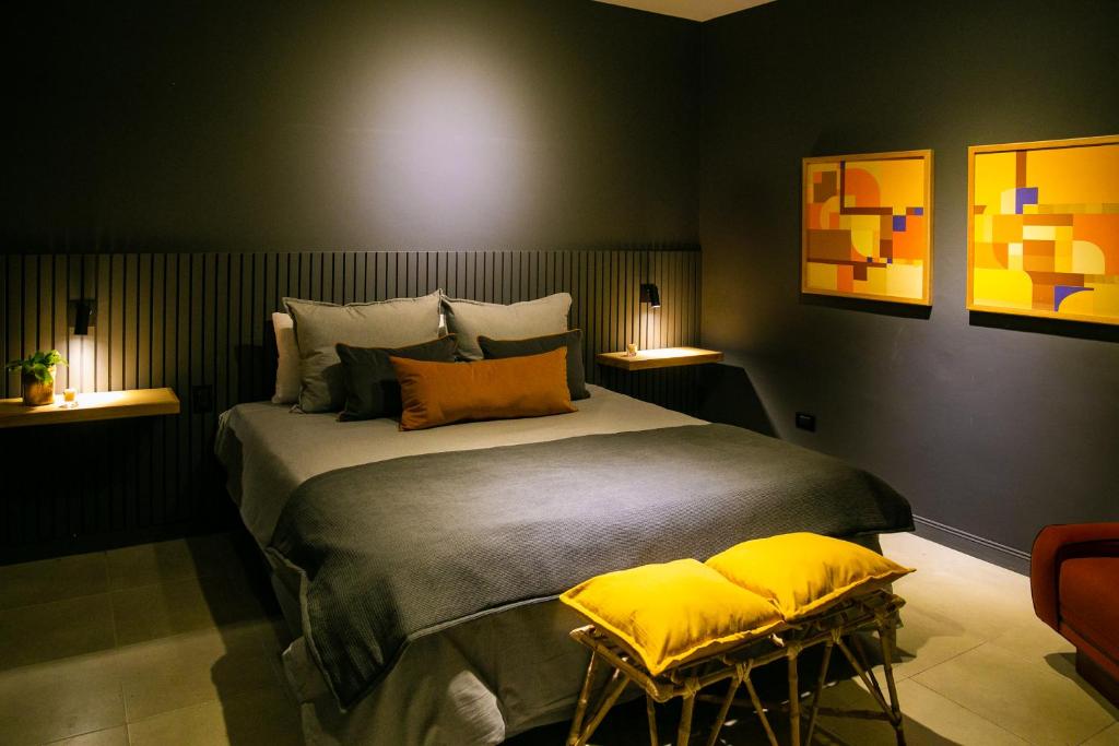 1 dormitorio con 1 cama grande con almohadas amarillas en Casa Rafaela Mendoza parque y ciudad en Mendoza