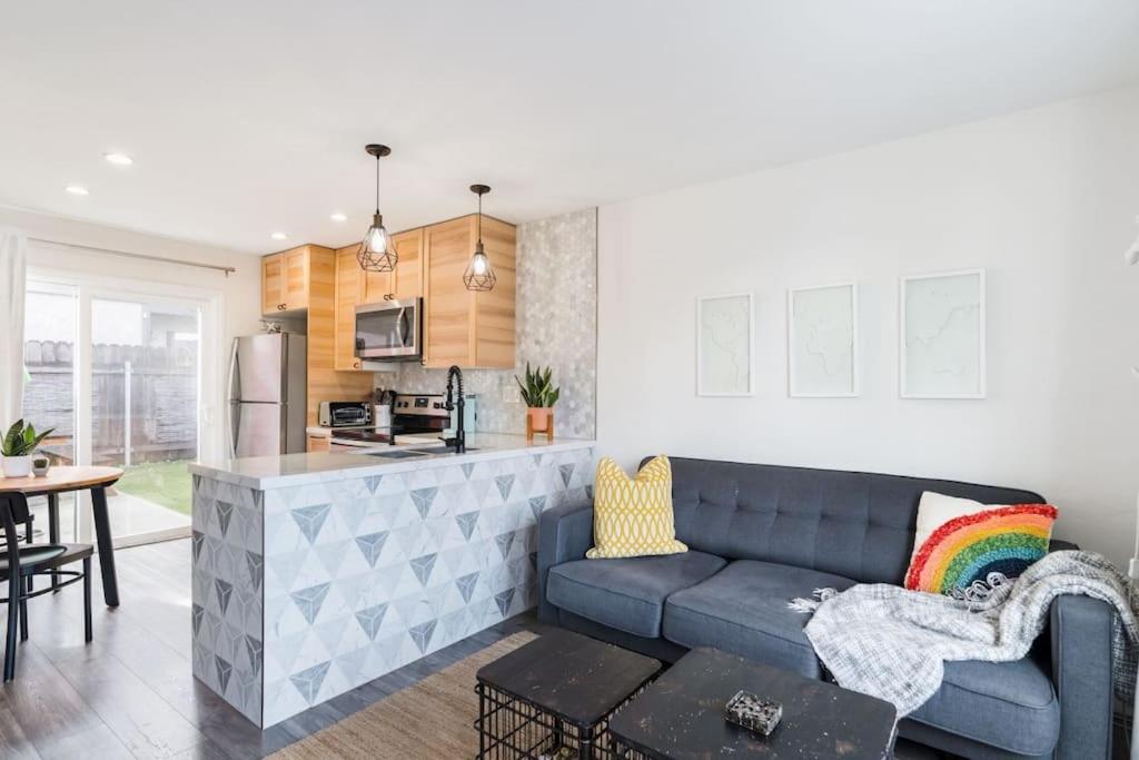 Casa Nova - Central San Diego FREE parking في سان دييغو: غرفة معيشة مع أريكة زرقاء ومطبخ