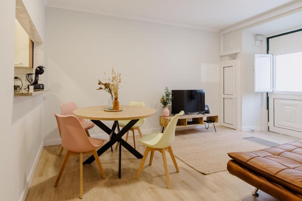 een keuken en een woonkamer met een tafel en stoelen bij Casa do Azulejo I in Setúbal