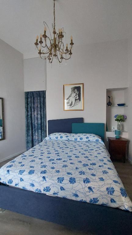ein Schlafzimmer mit einem blauen Bett und einem Kronleuchter in der Unterkunft ll Covo del Brigante in Melfi