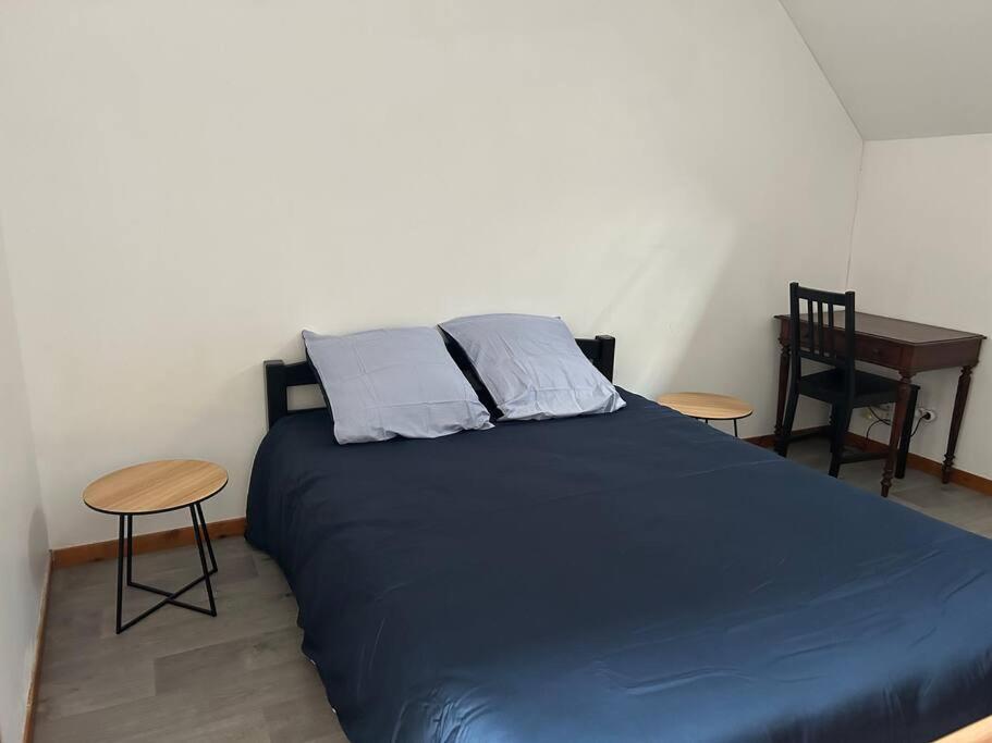 1 dormitorio con 1 cama azul con 2 sillas y mesa en T1 en duplex en La Riche