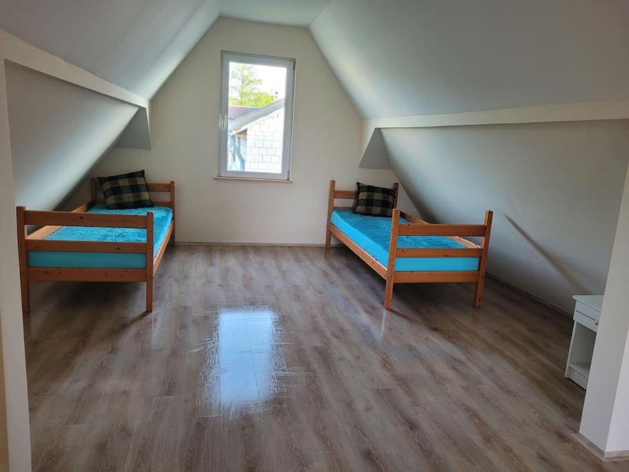 Zimmer im Dachgeschoss mit 2 Betten und einem Fenster in der Unterkunft Domek nad stawem in Juliopol