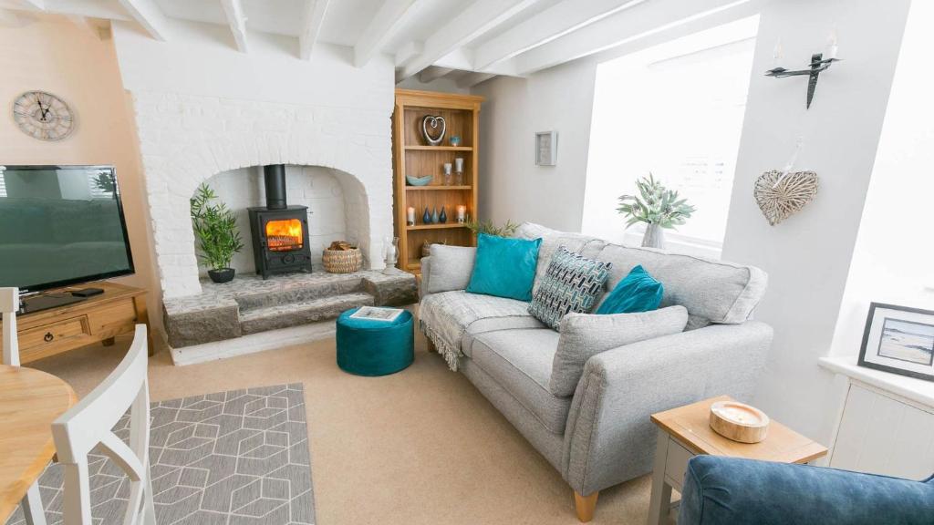 sala de estar con sofá y chimenea en Gower Cottage en Beaumaris