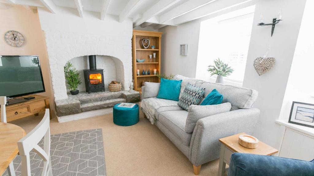 ein Wohnzimmer mit Couch und Kamin in der Unterkunft Gower Cottage in Beaumaris
