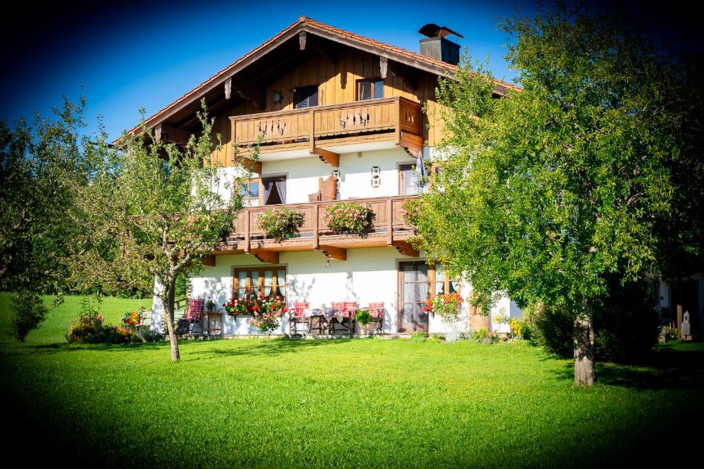 a large building with a balcony on top of a yard at Ferienwohnungen Hollweger in Ruhpolding