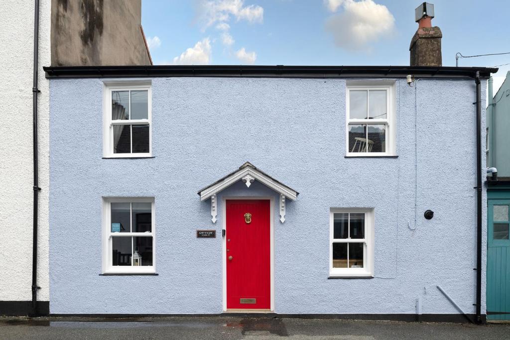 une maison bleue et rouge avec une porte rouge dans l'établissement Gwyndy, à Beaumaris