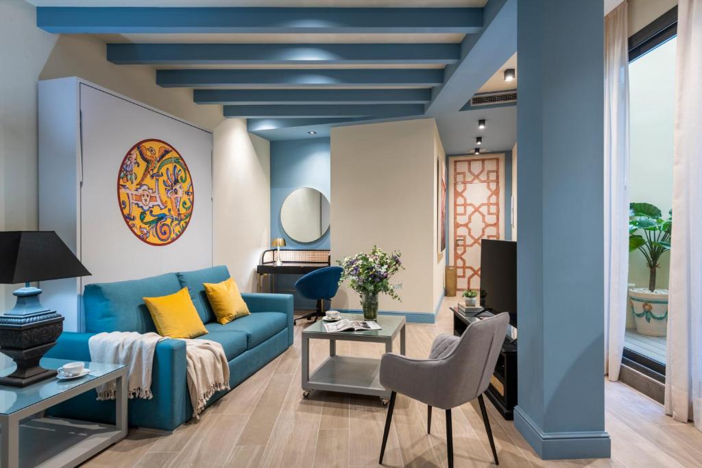 a living room with a blue couch and a table at La Rosa de la Alfalfa in Seville