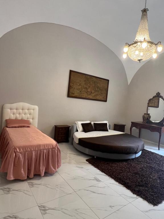 een slaapkamer met 2 bedden en een kroonluchter bij B&B Carlo di Borbone in Caserta