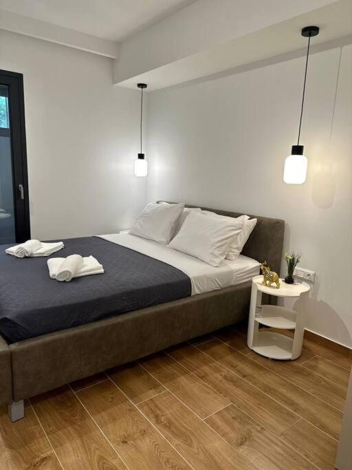 um quarto com uma cama grande e uma mesa lateral em Moschato Stylish Home 1 vipgreece em Piraeus