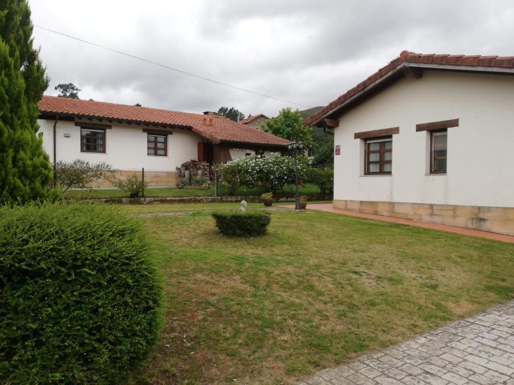 une maison avec une cour devant elle dans l'établissement Acogedor chalet de TRES HABITACIONES en el Valle de Cabuérniga, ideal para familias, grupos y mascotas SOMOS PET FRIENDLY, à Lamiña