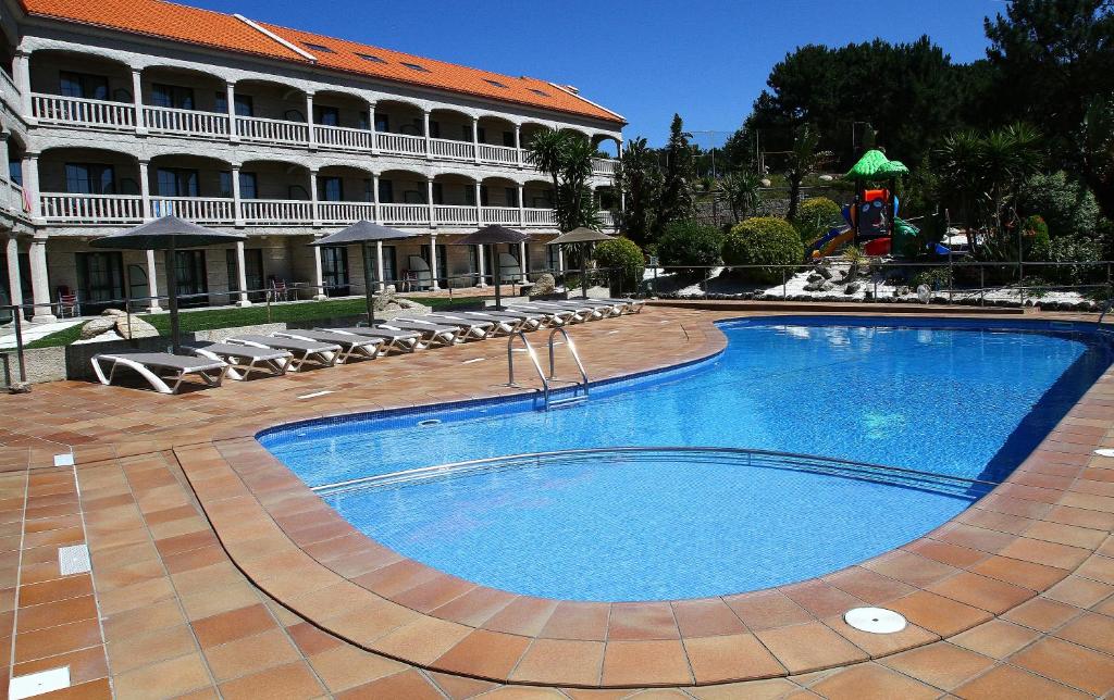 uma grande piscina em frente a um edifício em Apartamentos Coral Do Mar II em Portonovo