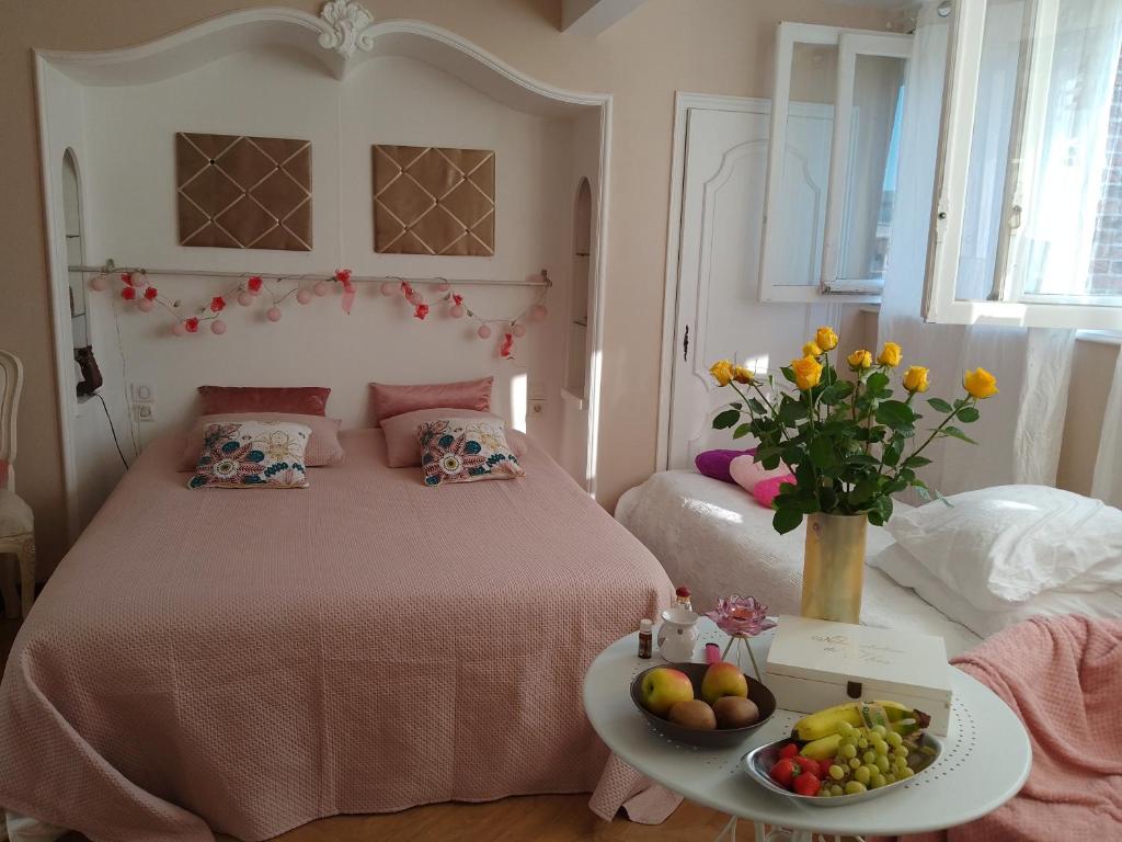 ヴィルヌーヴ・ダスクにあるLa Lilloise Villeneuve D'Ascq GD STADE Mauroyのベッドルーム1室(ベッド1台付)、テーブルにフルーツのトレイを用意しています。