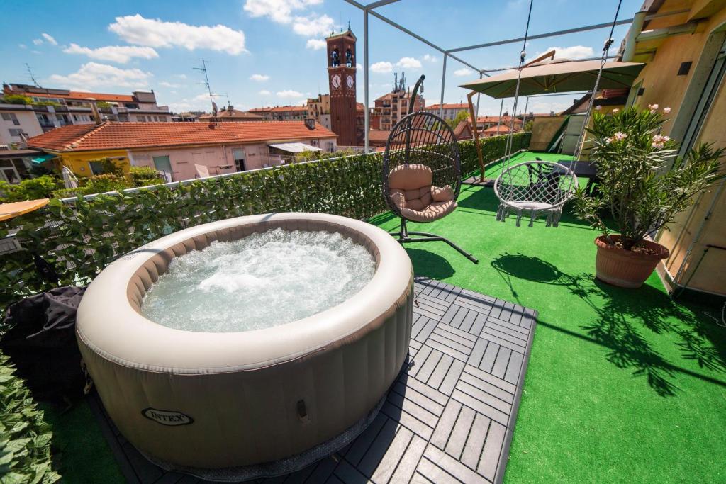 a large hot tub on a balcony with green grass at Spazioso appartamento con terrazzo Navigli , Bocconi IULM NABA in Milan
