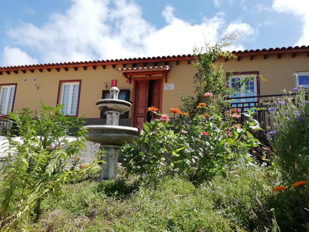 a garden with a bird bath in front of a house at Finca Las Tapias, Casa Mañé in Puerto de la Cruz