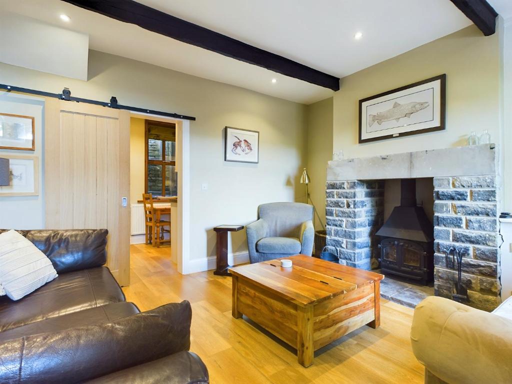 a living room with a couch and a fireplace at Stoneswood Cottage & Garden, Delph, Saddleworth in Delph