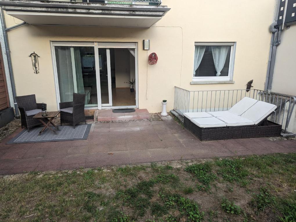 un patio con un sofá blanco y una mesa en Ferienwohnung Mila, Scheidt en Saarbrücken