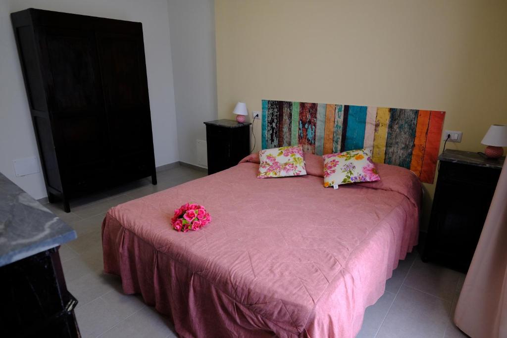 Un dormitorio con una cama rosa con flores. en Casa Celeste, en Nocera Umbra
