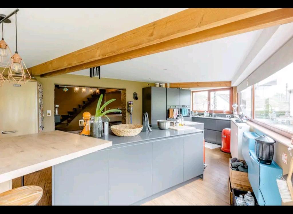 a kitchen with white cabinets and a counter top at Gee's Shared home in Liège