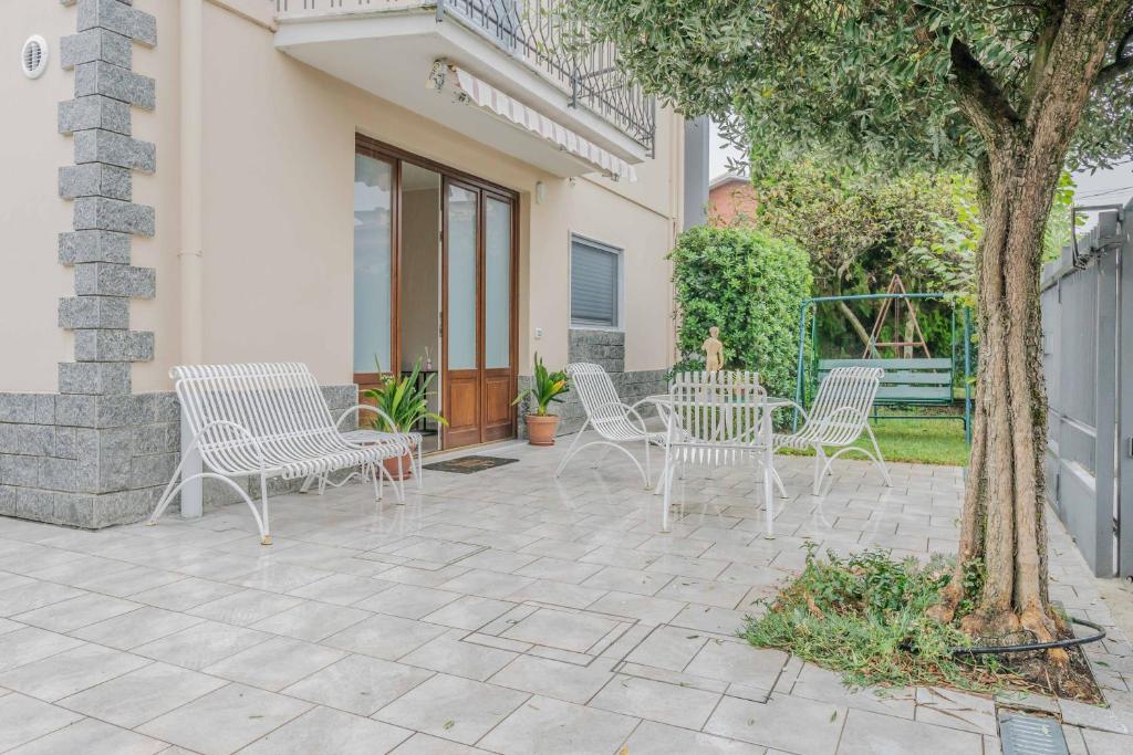 un patio con sedie, tavolo e albero di [Il giardino di Alfonso] - Malpensa Airport relax a Samarate