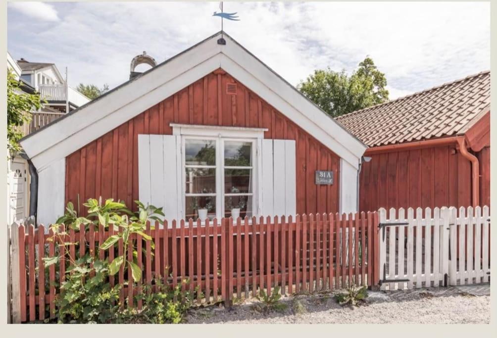 a red and white church with a fence at Historisk Charm i Hjärtat av Gamla Stan Kalmar in Kalmar