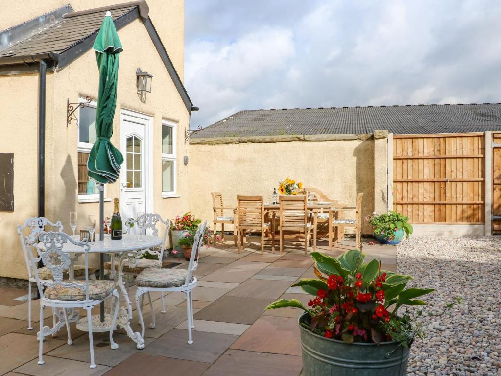 a patio with a table and chairs and an umbrella at North Farm in Stockton-on-Tees