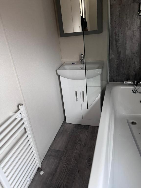 a small bathroom with a sink and a mirror at Langford Lodge in Great Billing