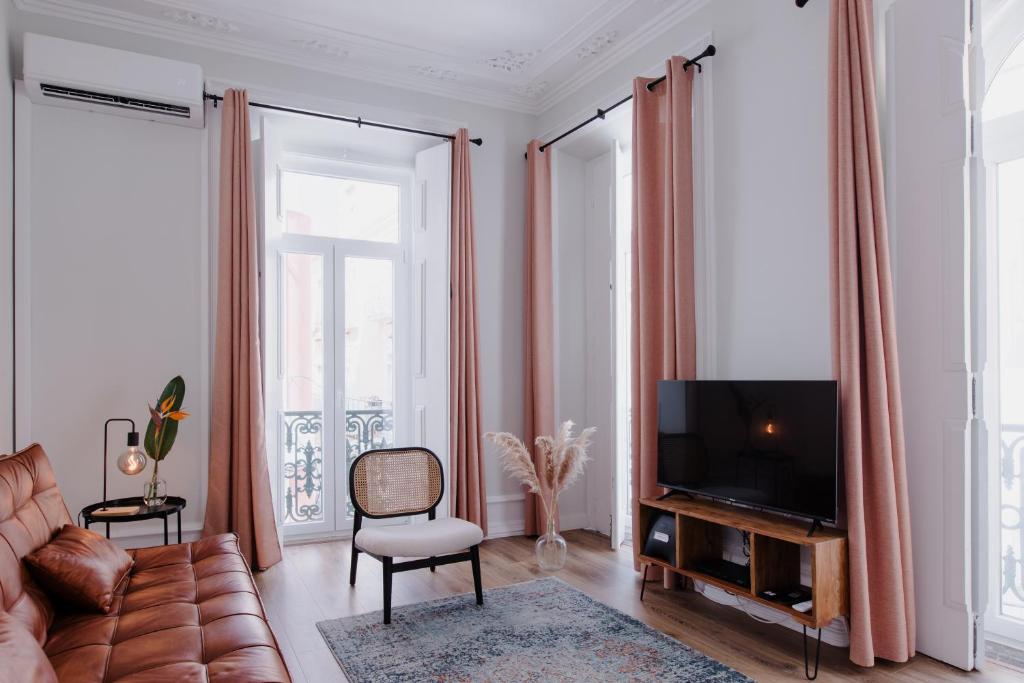 a living room with a couch and a television at Casa do Azulejo II in Setúbal