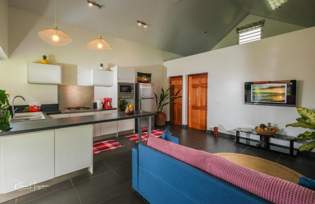 a kitchen with a counter and a blue couch at POELANI in Faaone