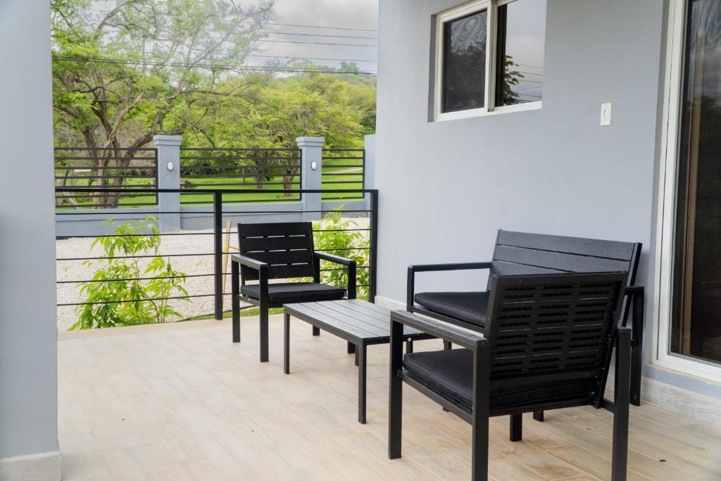 Duas cadeiras pretas e uma mesa na varanda em Condominios Akira em Tamarindo