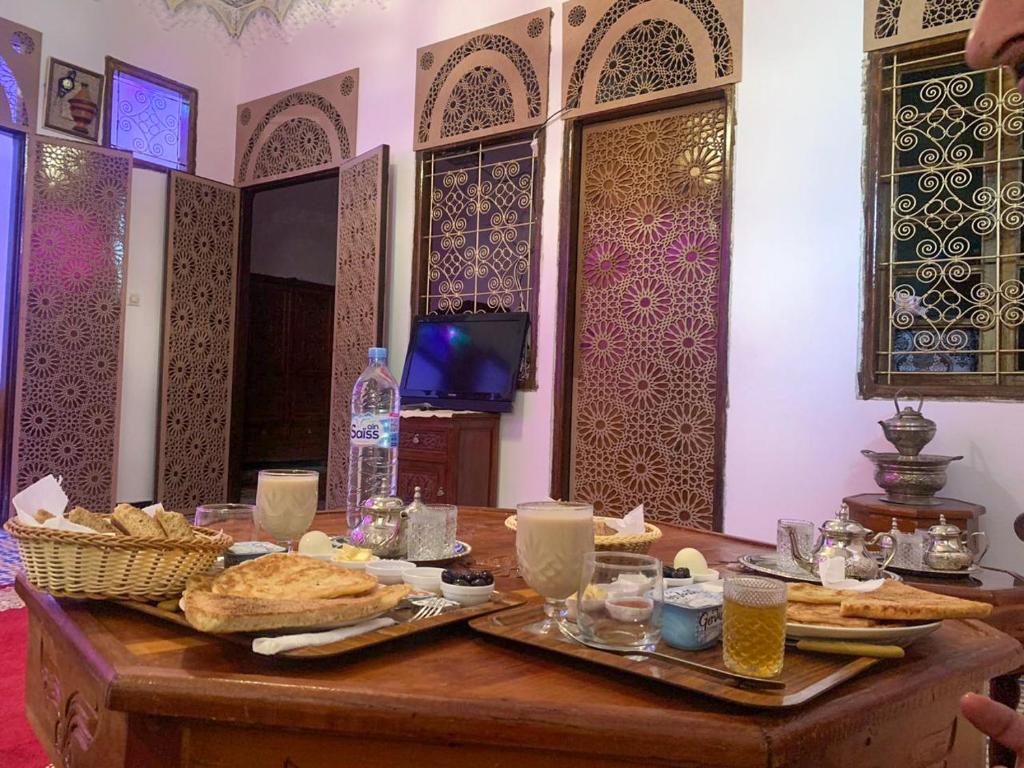 a table with bread and drinks on it in a room at Riad Sibari in Meknès