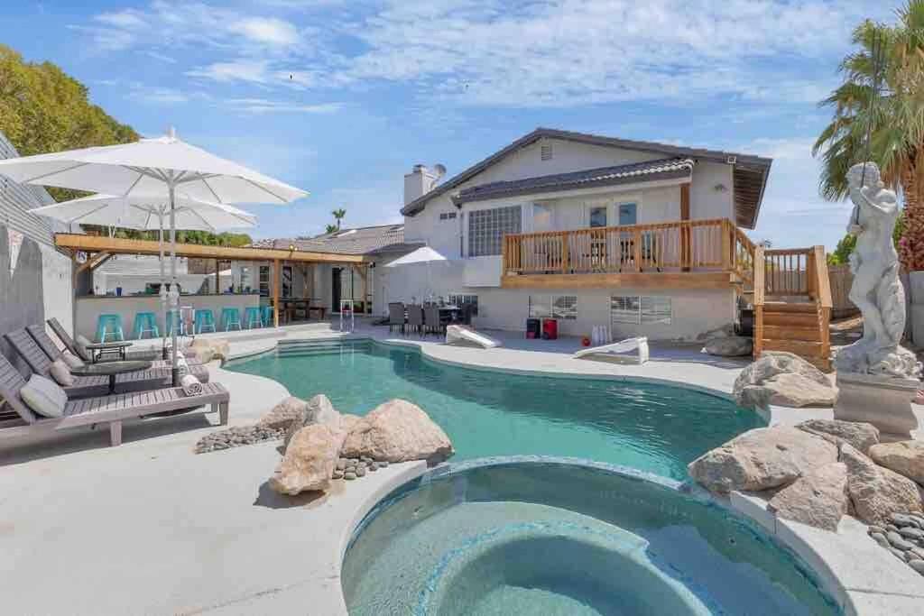 a swimming pool with rocks and a house at Bermuda Fun Oasis in Bermuda Dunes