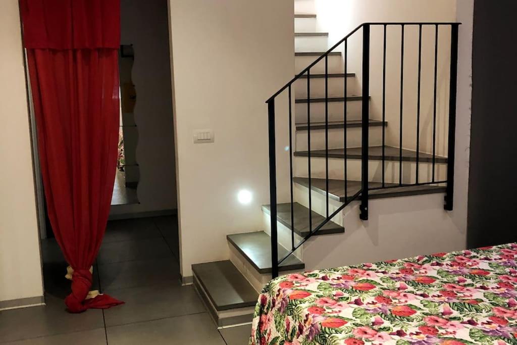 une chambre avec un escalier et un rideau rouge dans l'établissement Loft con ampia terrazza a 500 MT da Piazza Bovio., à Piombino