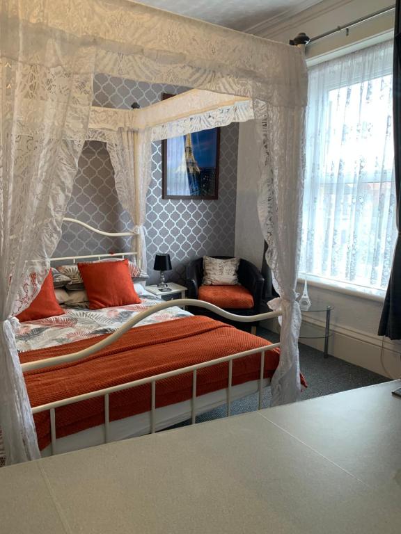 een slaapkamer met een hemelbed met oranje kussens bij Hornby Villa 4*B&B Couples & Families Only in Blackpool