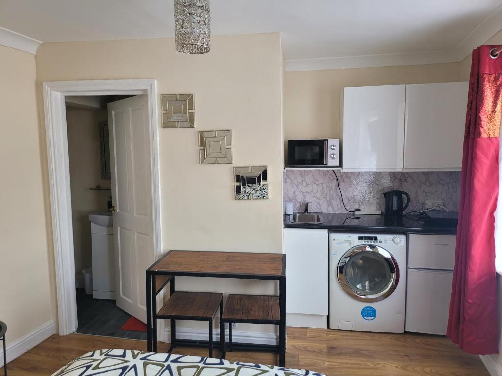 a kitchen with a table and a washing machine at Lovely 1-Bed Studio in Reading in Reading