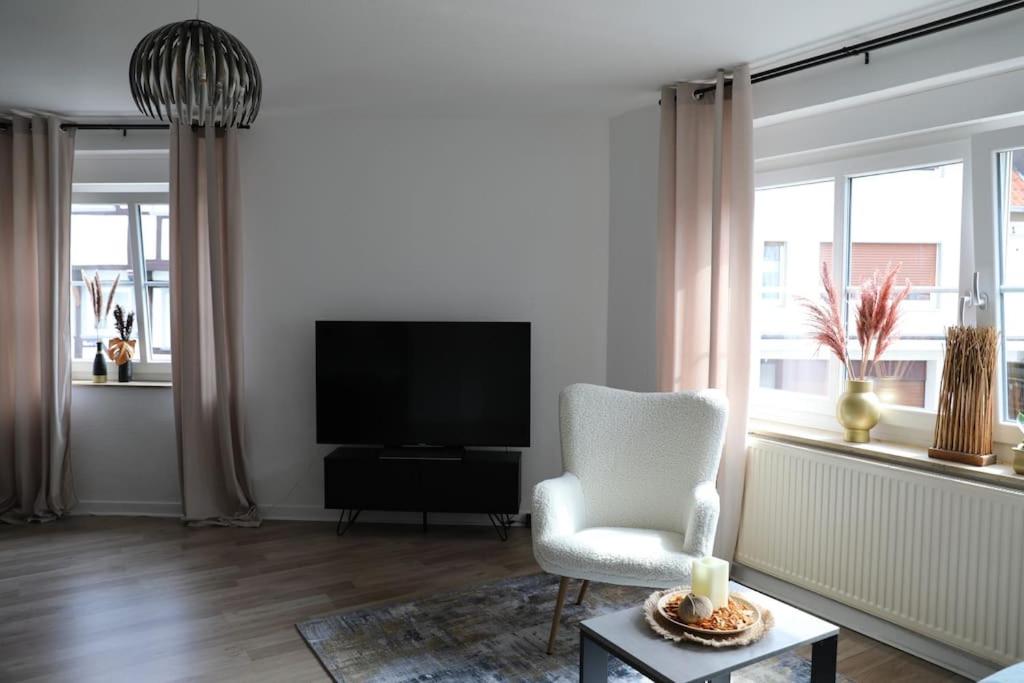 a living room with a chair and a television at Soester Altstadt Apartment in Soest