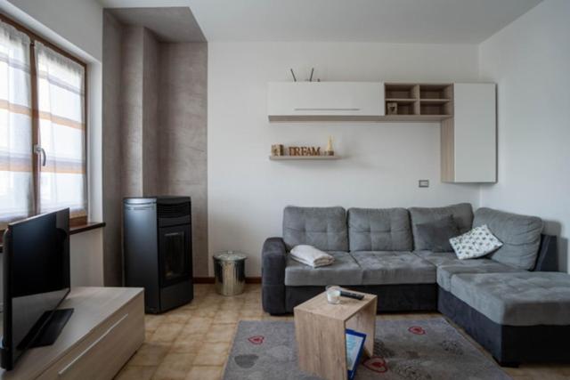 ein Wohnzimmer mit einem Sofa und einem TV in der Unterkunft VIVI SERENO, uno stile si vita! in Grosio