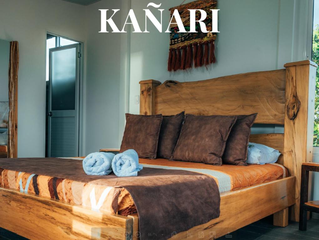 1 dormitorio con cama de madera y toallas en Pachamama finca hotel - spa en Dosquebradas