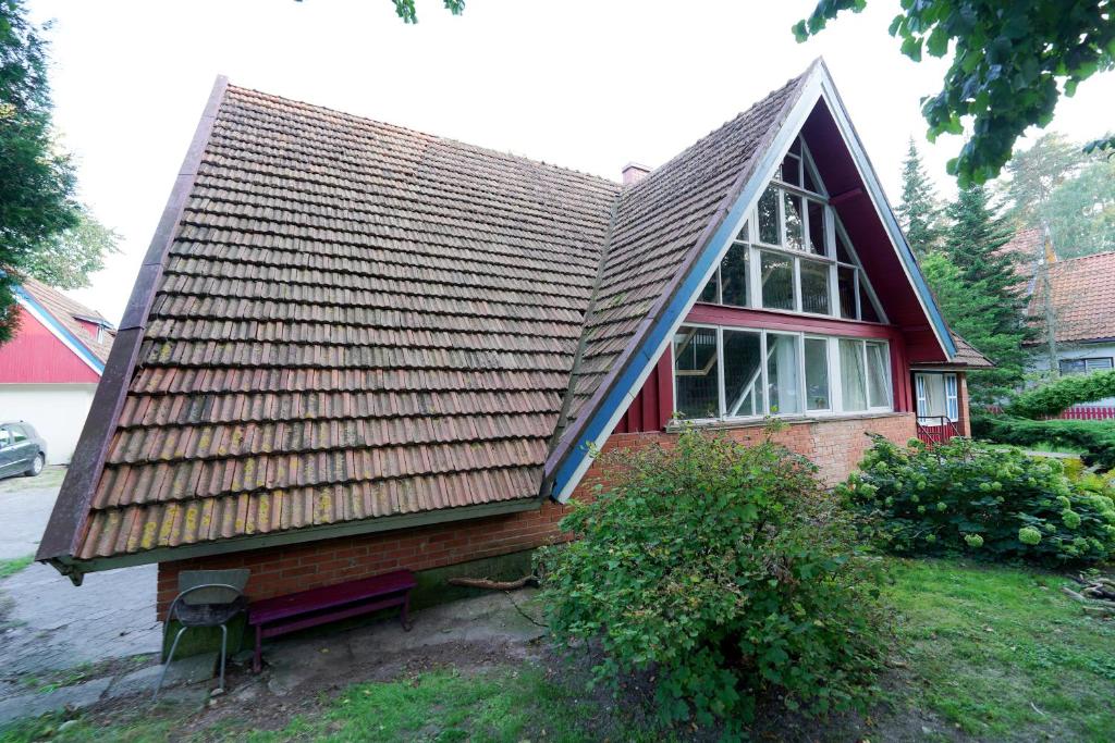 una pequeña casa con techo marrón en Skruzdėlynas, en Nida