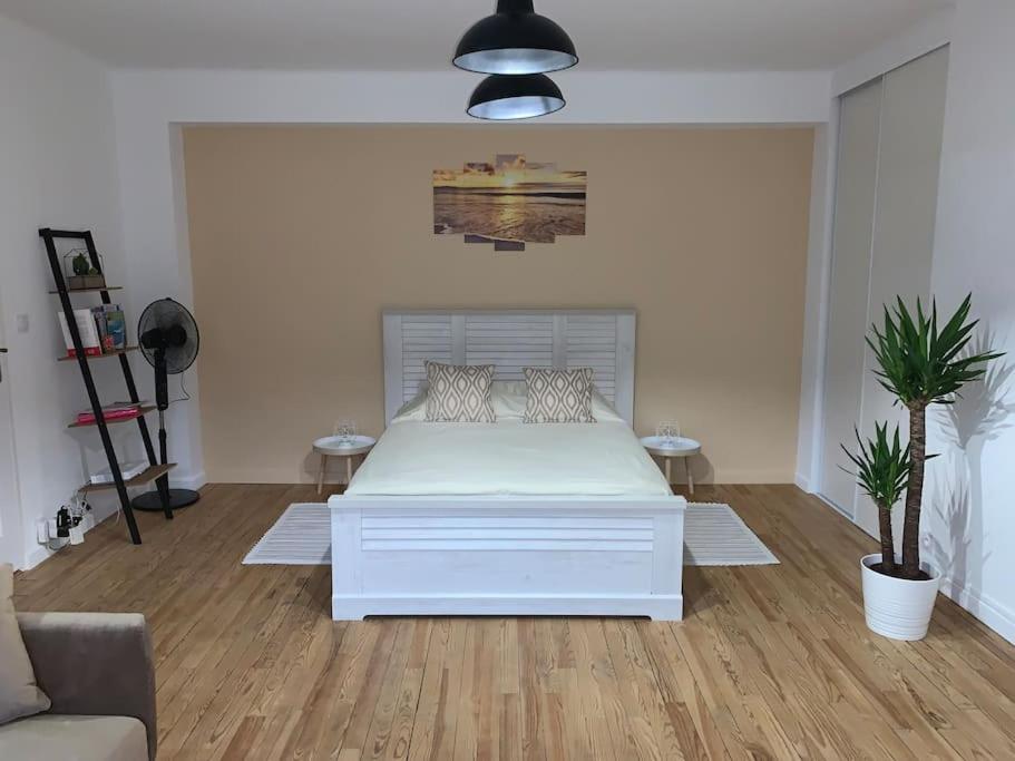 une chambre avec un lit blanc dans une pièce dans l'établissement Au Sunrise Studio, à Thonon-les-Bains