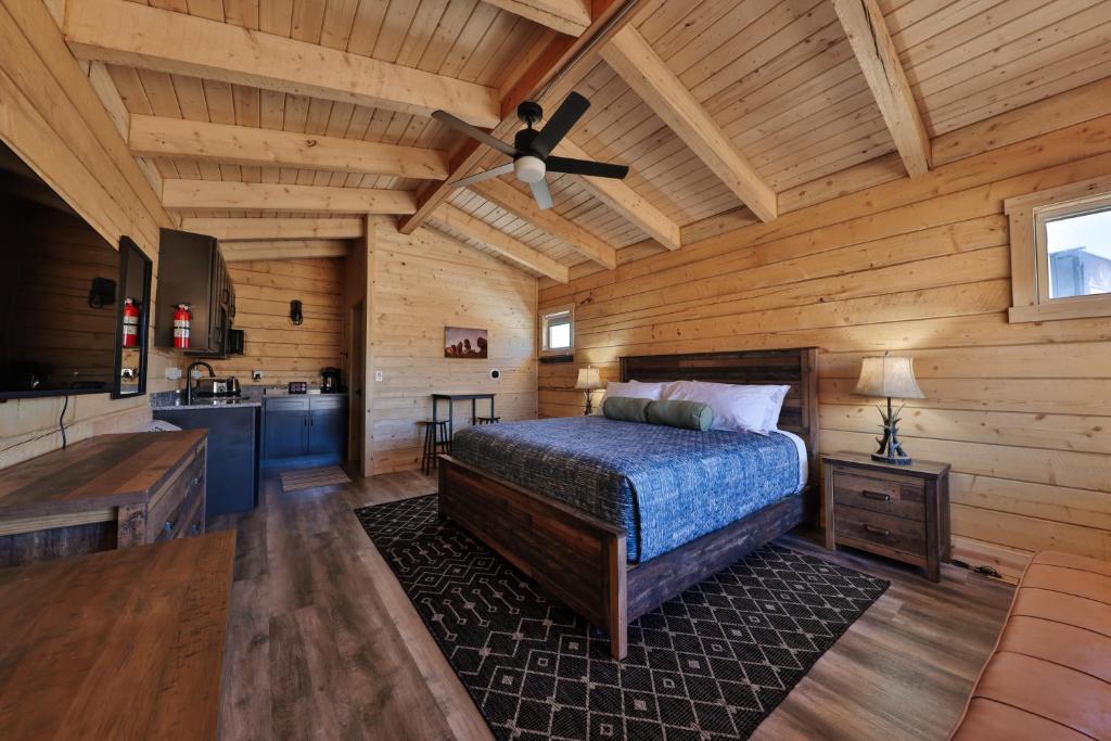 a bedroom with a bed and a kitchen in a cabin at Pet Friendly Cabins in Hanksville Utah in Hanksville