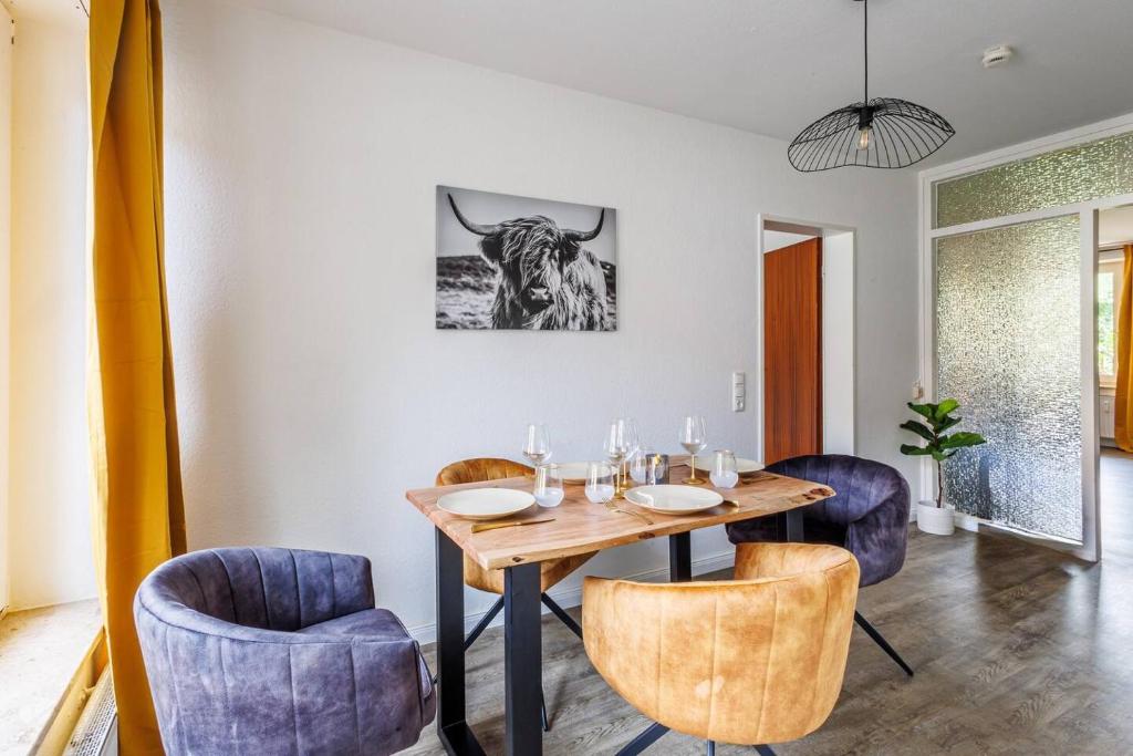 een eetkamer met een tafel en een stierenfoto aan de muur bij Traumhaftes Domizil mit Tiefgarage in Stade