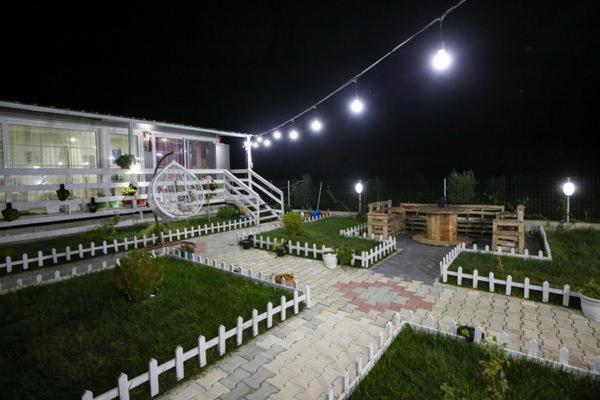 a backyard at night with a building with lights at Entire Villa Niku with Beautiful Garden in Vlorë